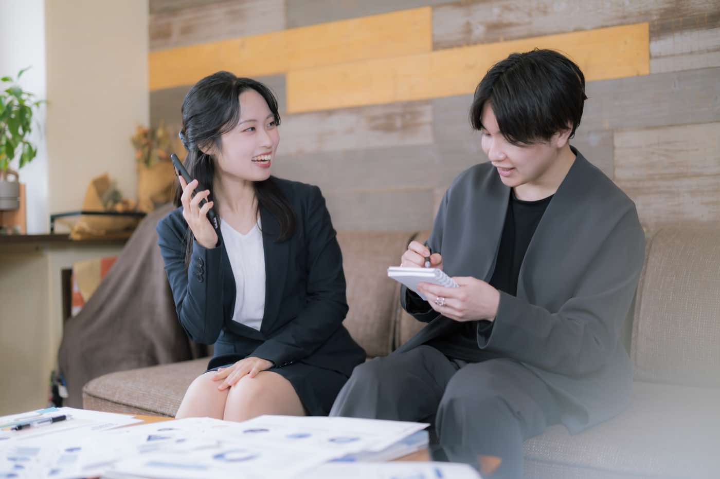 若手社員の男女が笑顔で仕事を進める様子