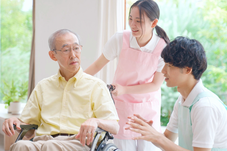 車椅子に乗った高齢者と介護士